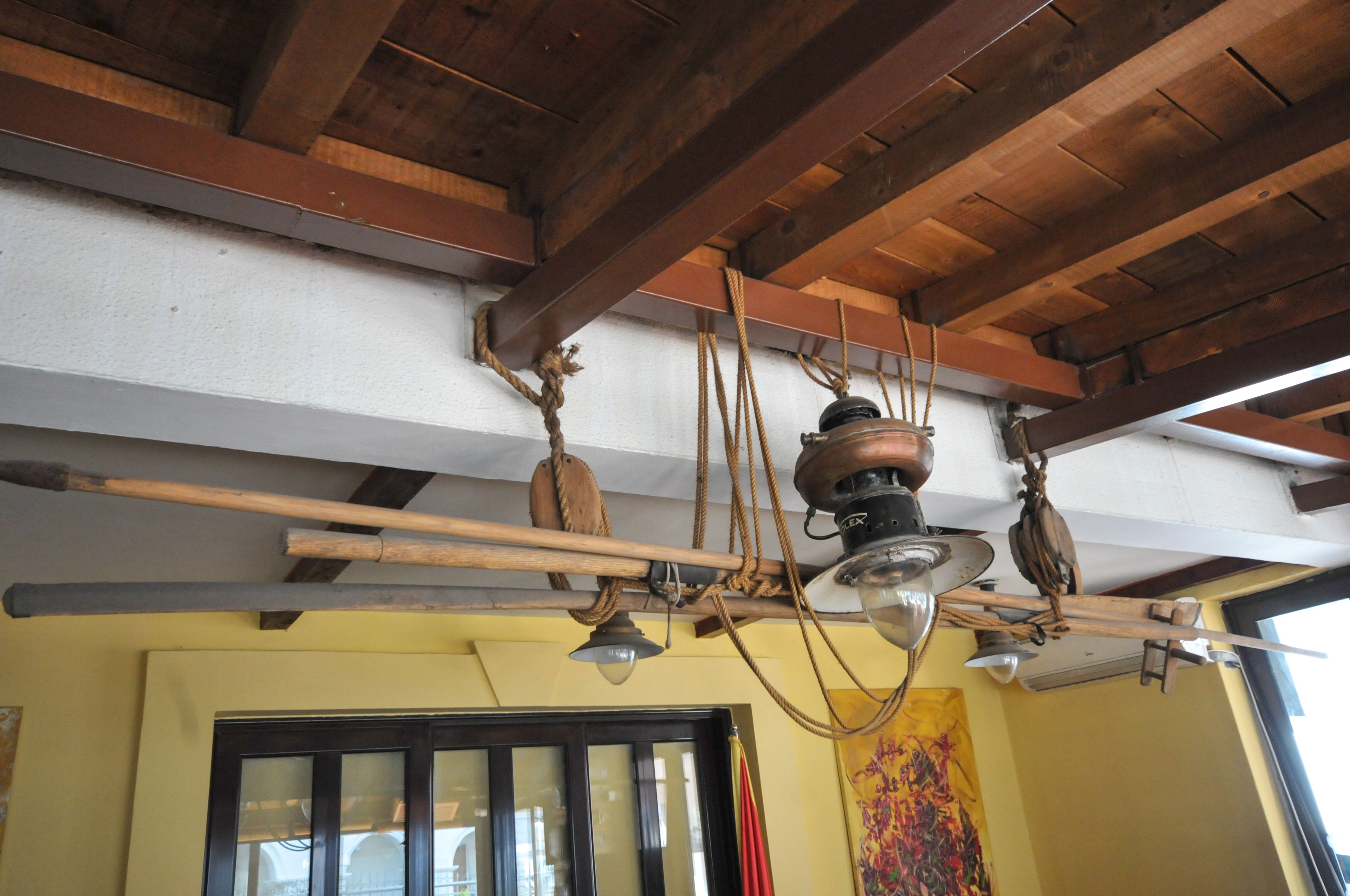 A ceiling with wooden beams and a hanging light fixture.