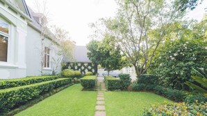 Un jardín cuidado con un camino de piedra que lleva a una casa.