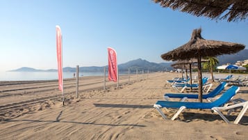 Praia particular, espreguiçadeiras, guarda-sóis, toalhas de praia