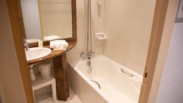 Une salle de bain avec un lavabo, un miroir et une baignoire.