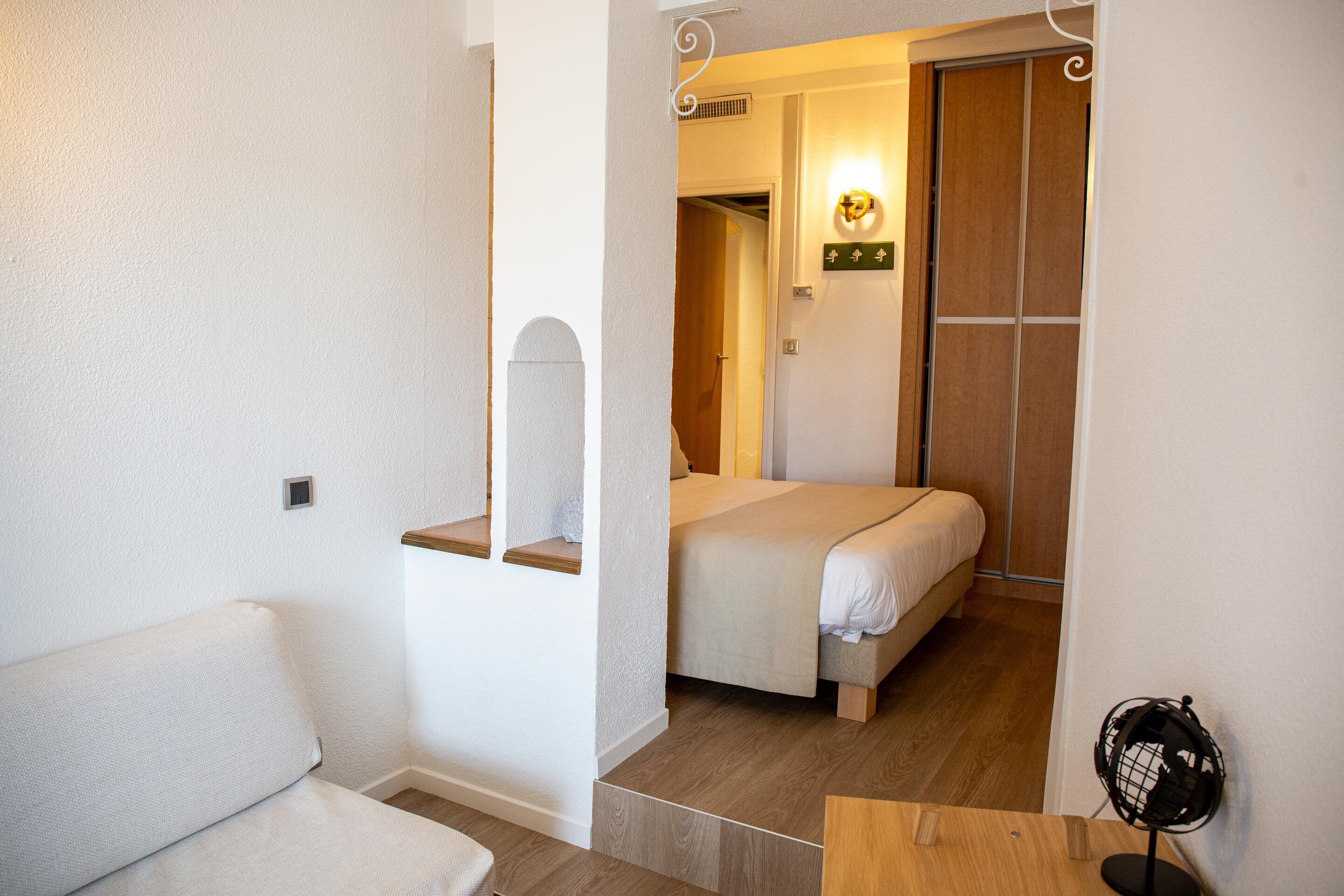 Ein Schlafzimmer mit einem Bett, einem Nachttisch, einem Stuhl und einem kleinen Tisch.