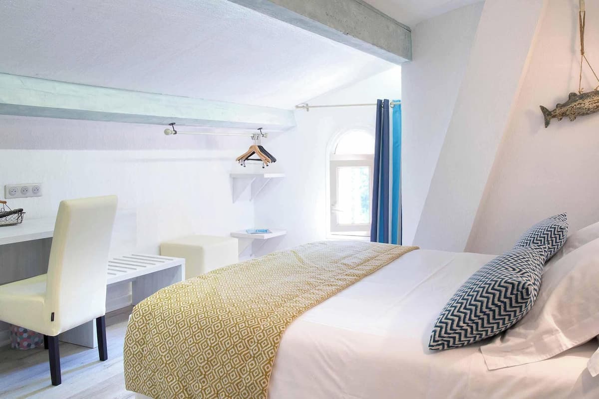 A modern bedroom with a bed, a desk, and a chair.