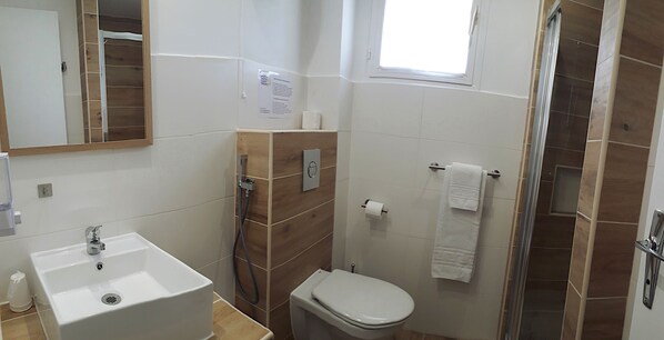 Un baño con lavamanos, inodoro y ducha.