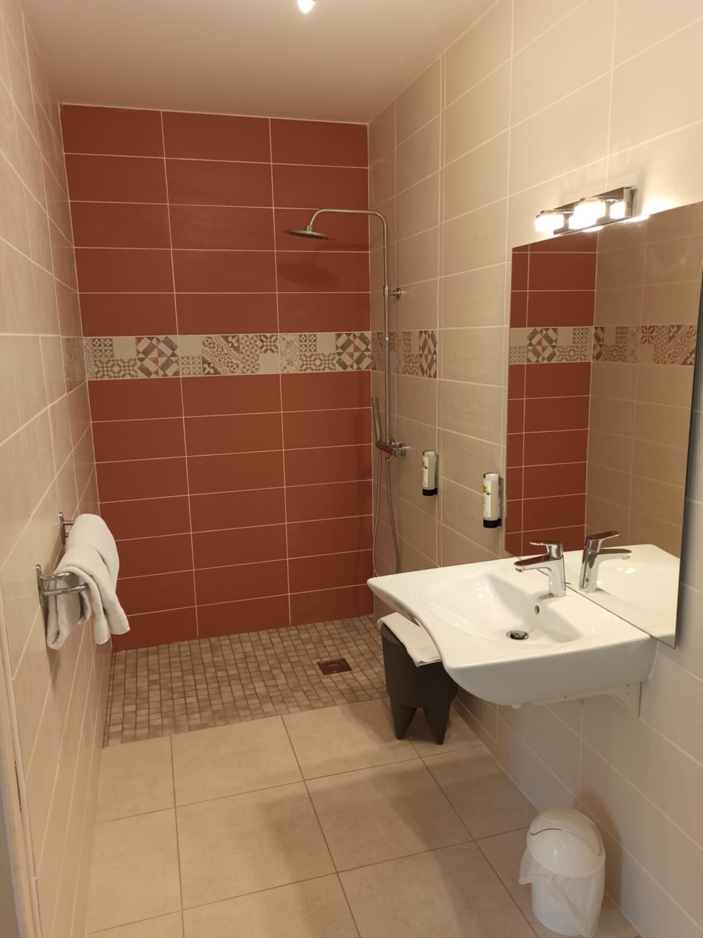 Een badkamer met een douche, wastafel en toilet.