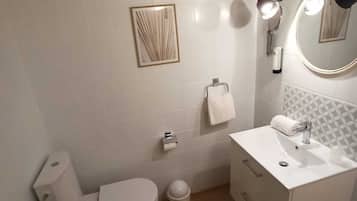 Un bagno con il water, lavandino e vasca da bagno.