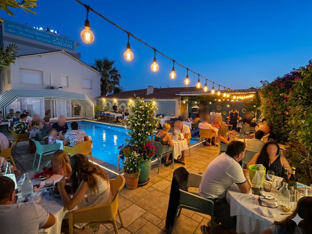 An outdoor dining area with tables and chairs, a pool, and string lights.
