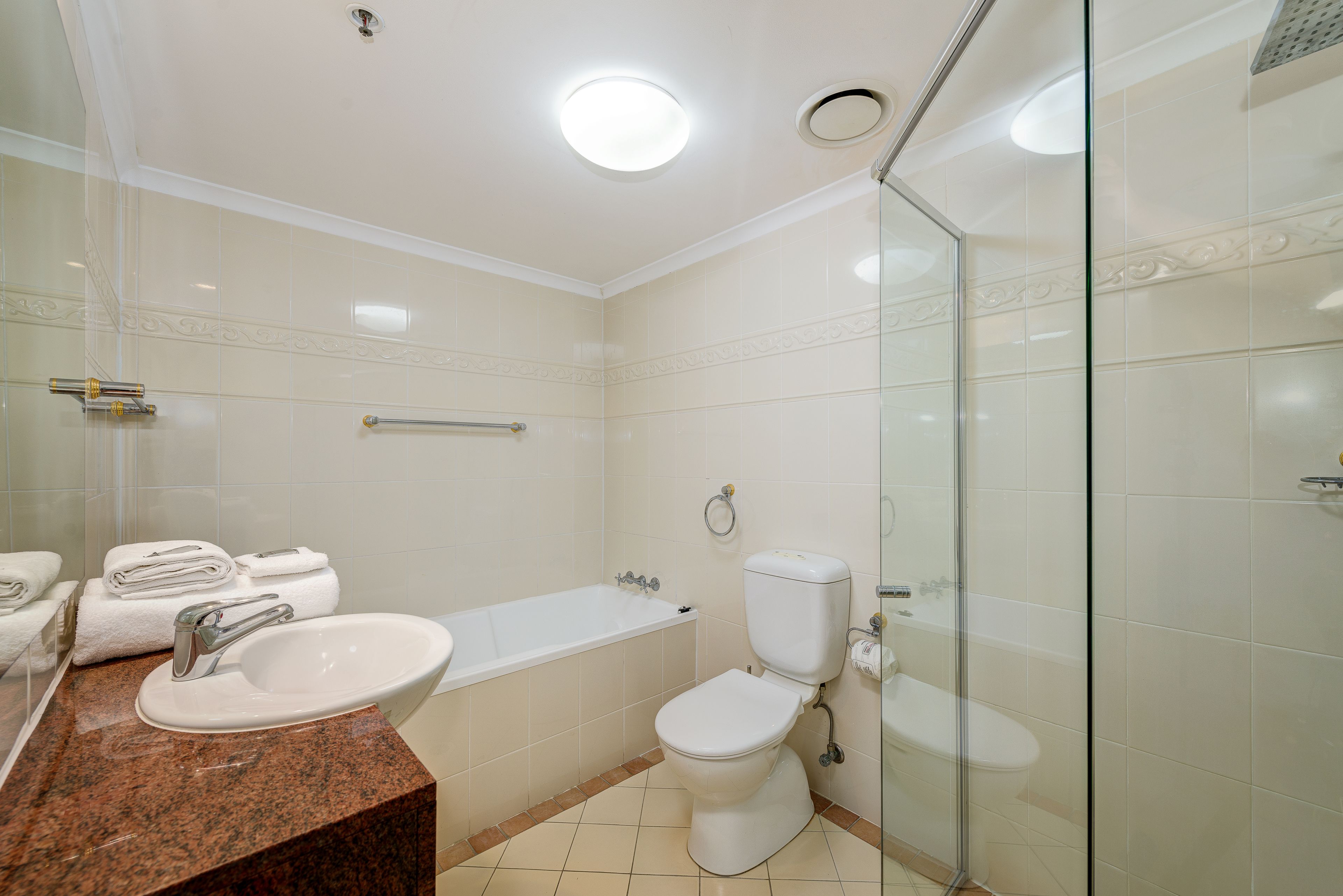 A modern bathroom with a sink, toilet, and bathtub.