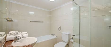 A modern bathroom with a sink, toilet, and bathtub.