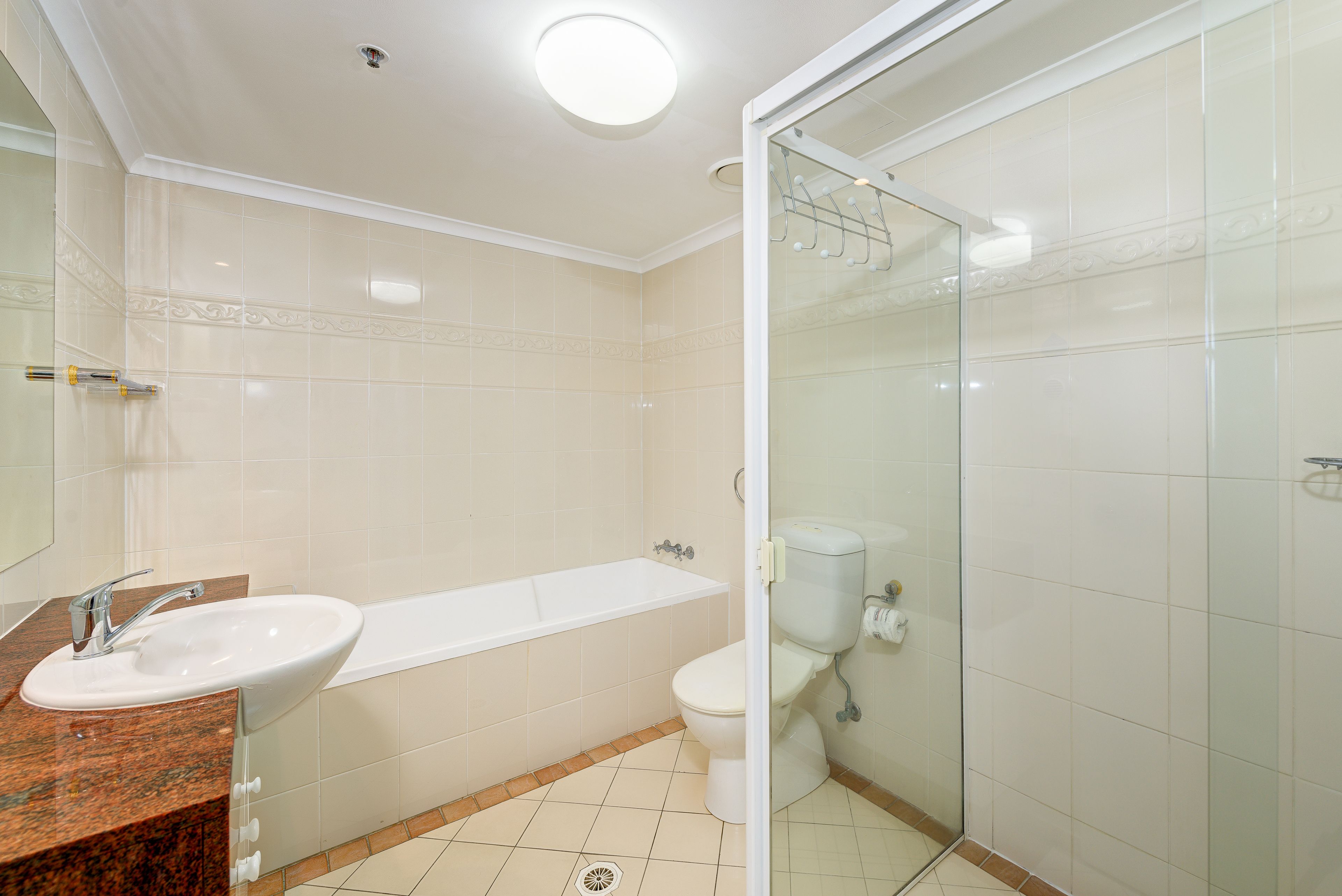 A bathroom with a sink, bathtub, toilet, and glass shower enclosure.