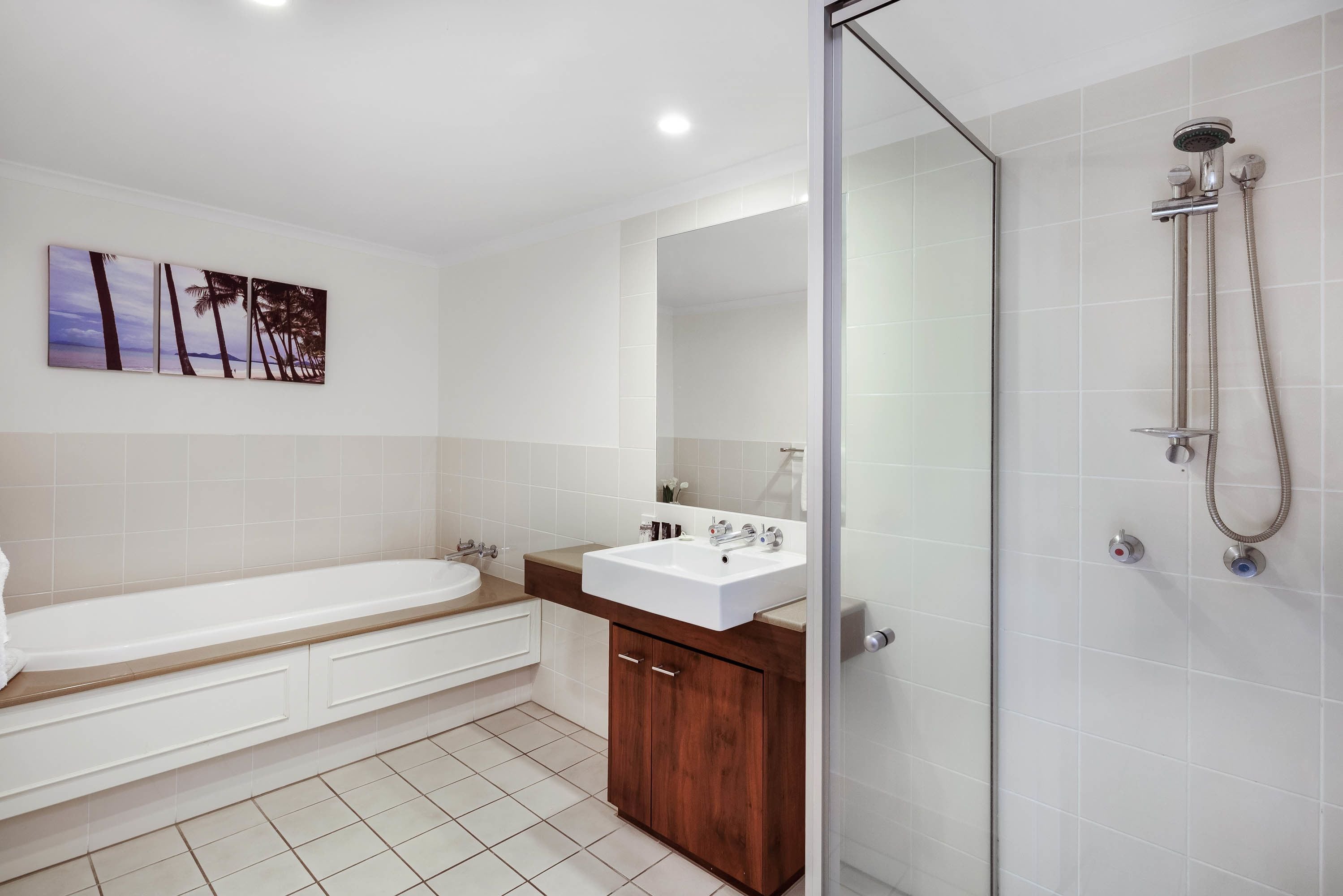 Une salle de bain moderne équipée d’une baignoire, d’un lavabo et d’une douche séparée par des parois en verre.