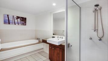 Un bagno moderno con vasca, lavabo e cabina doccia in vetro.