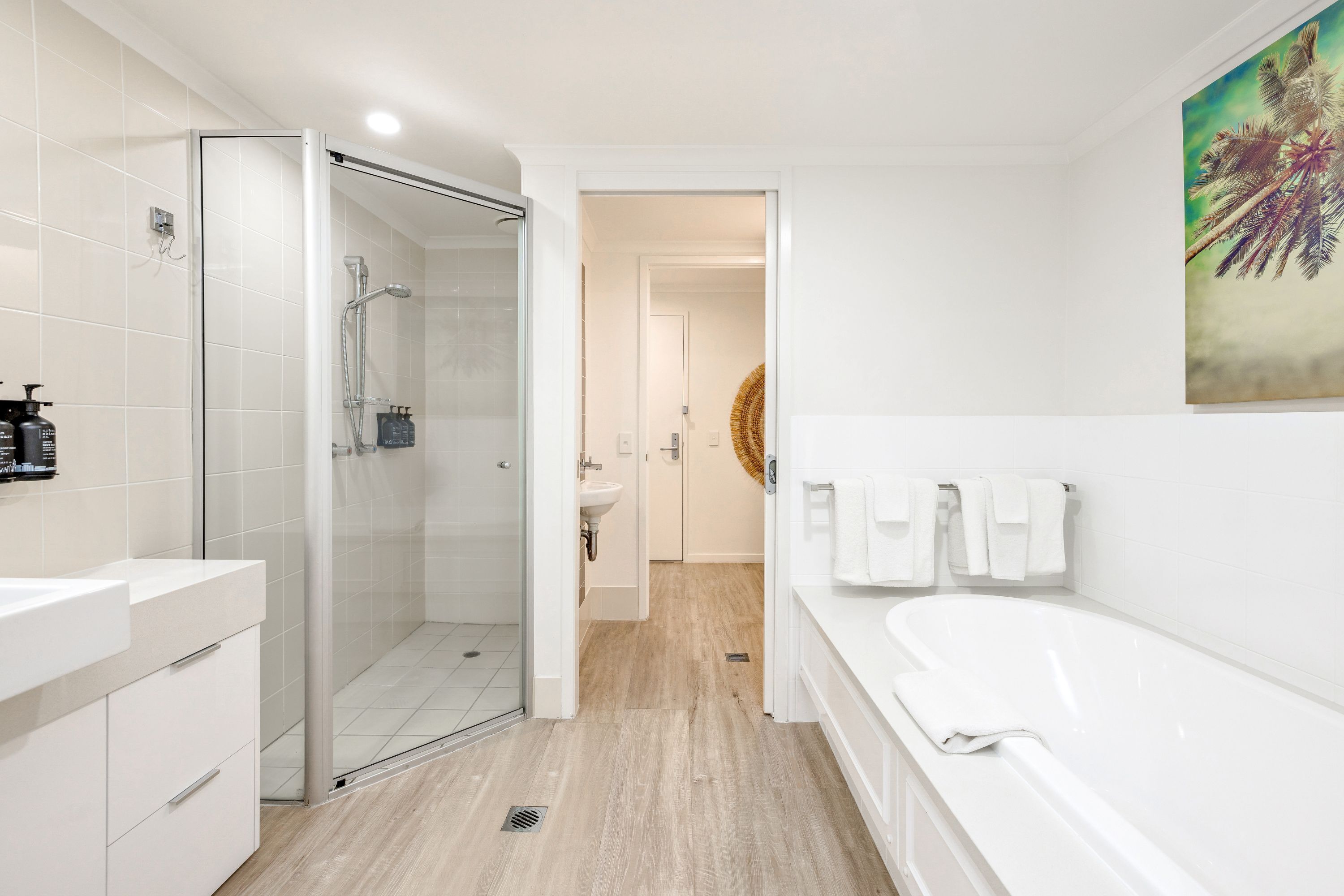 A modern bathroom with a glass-enclosed shower, a white sink, and a bathtub.