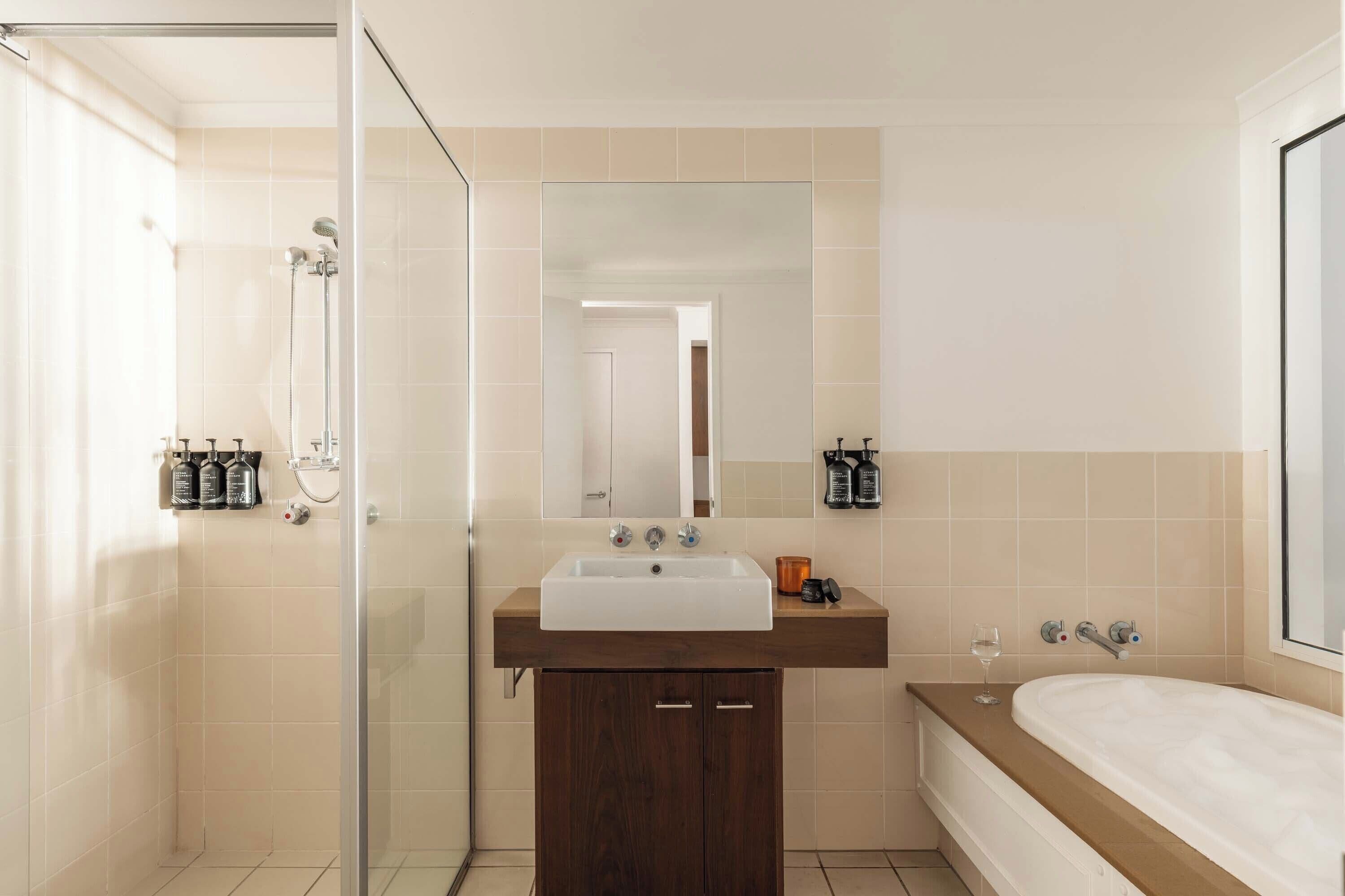 A modern bathroom with a shower, sink, and bathtub.