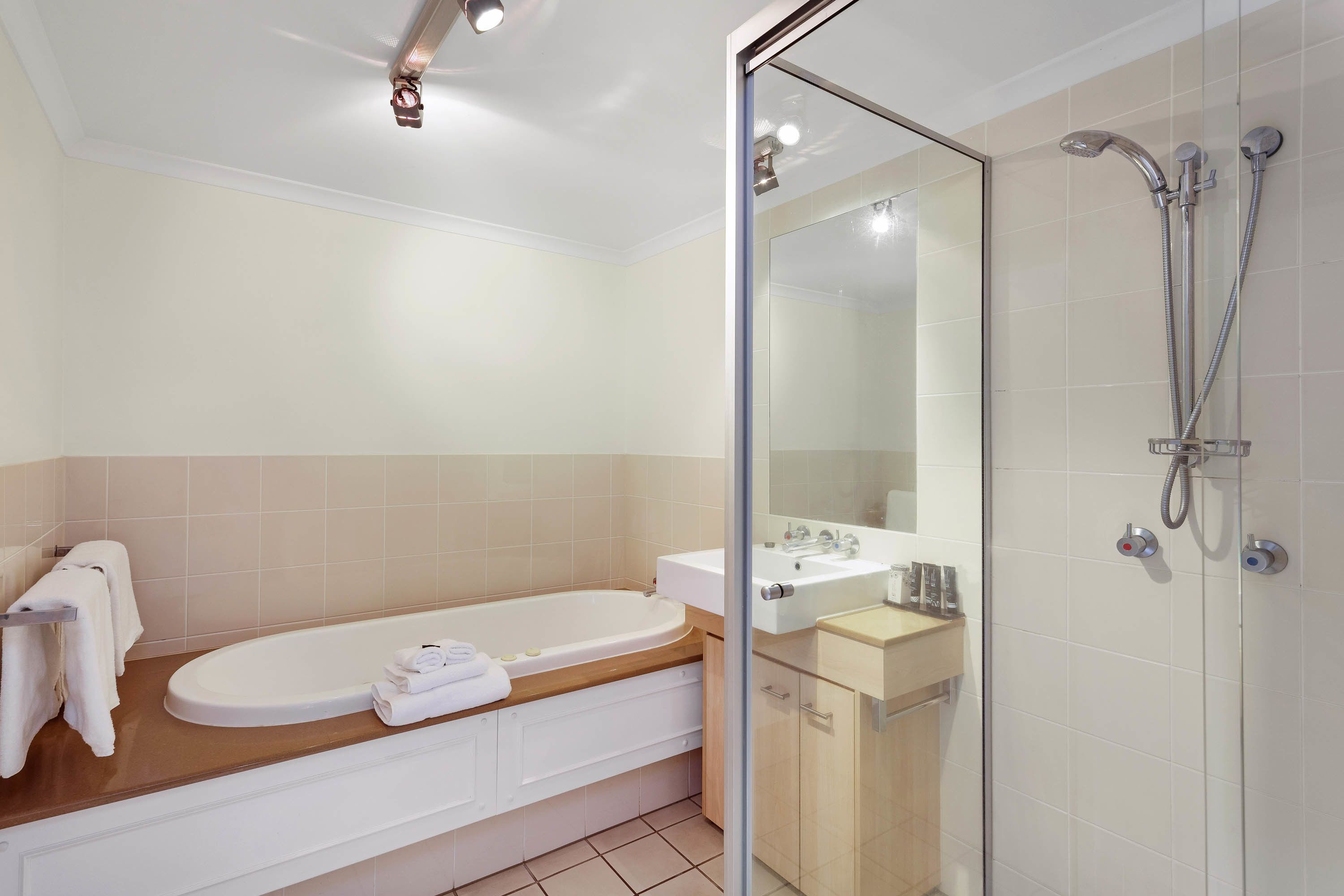 A modern bathroom with a bathtub, a shower, and a sink.