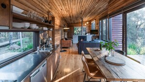 Una cucina moderna con travi in legno, elettrodomestici in acciaio inossidabile e un'ampia finestra che si affaccia su un giardino.