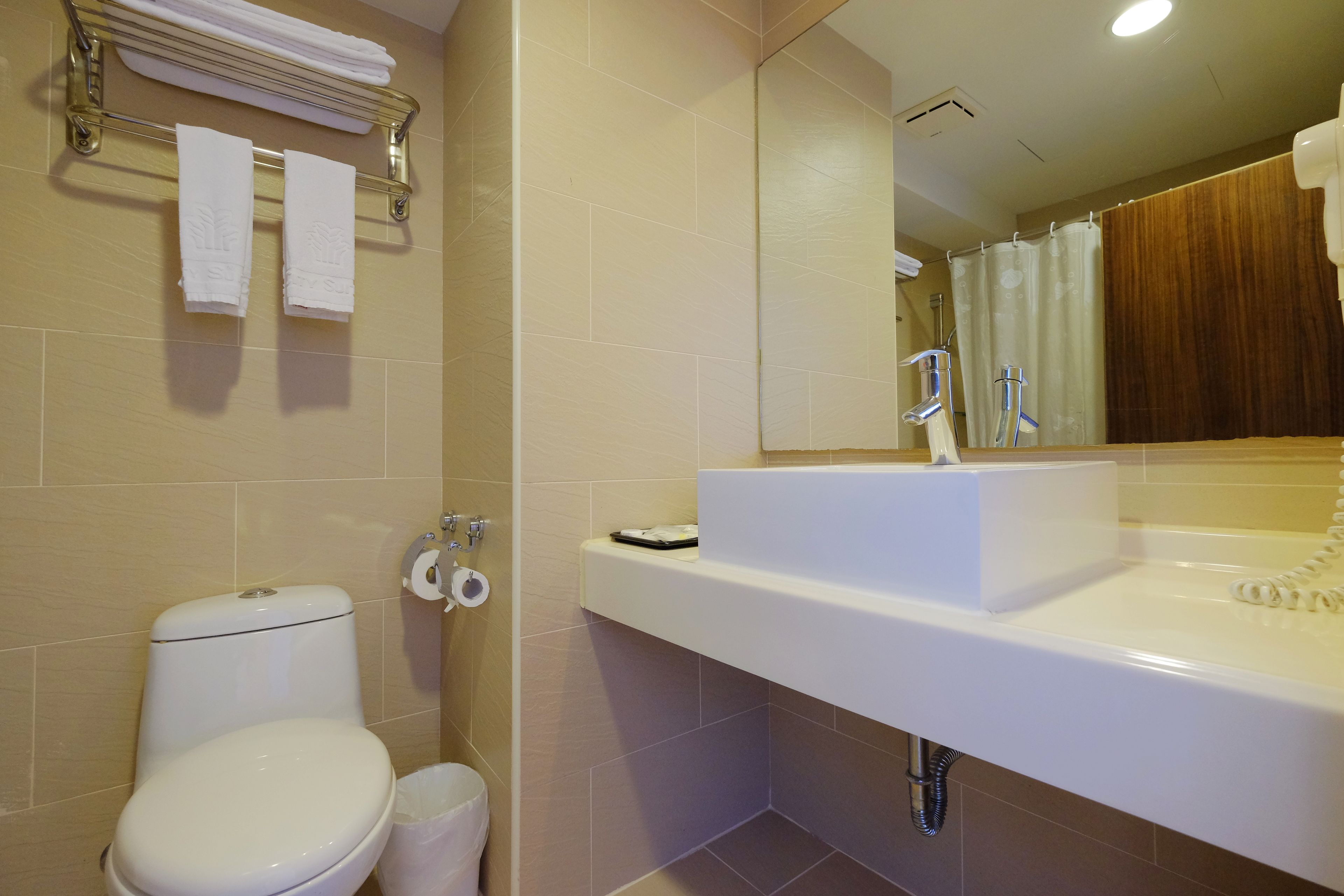 A modern bathroom with a toilet, sink, and shower.