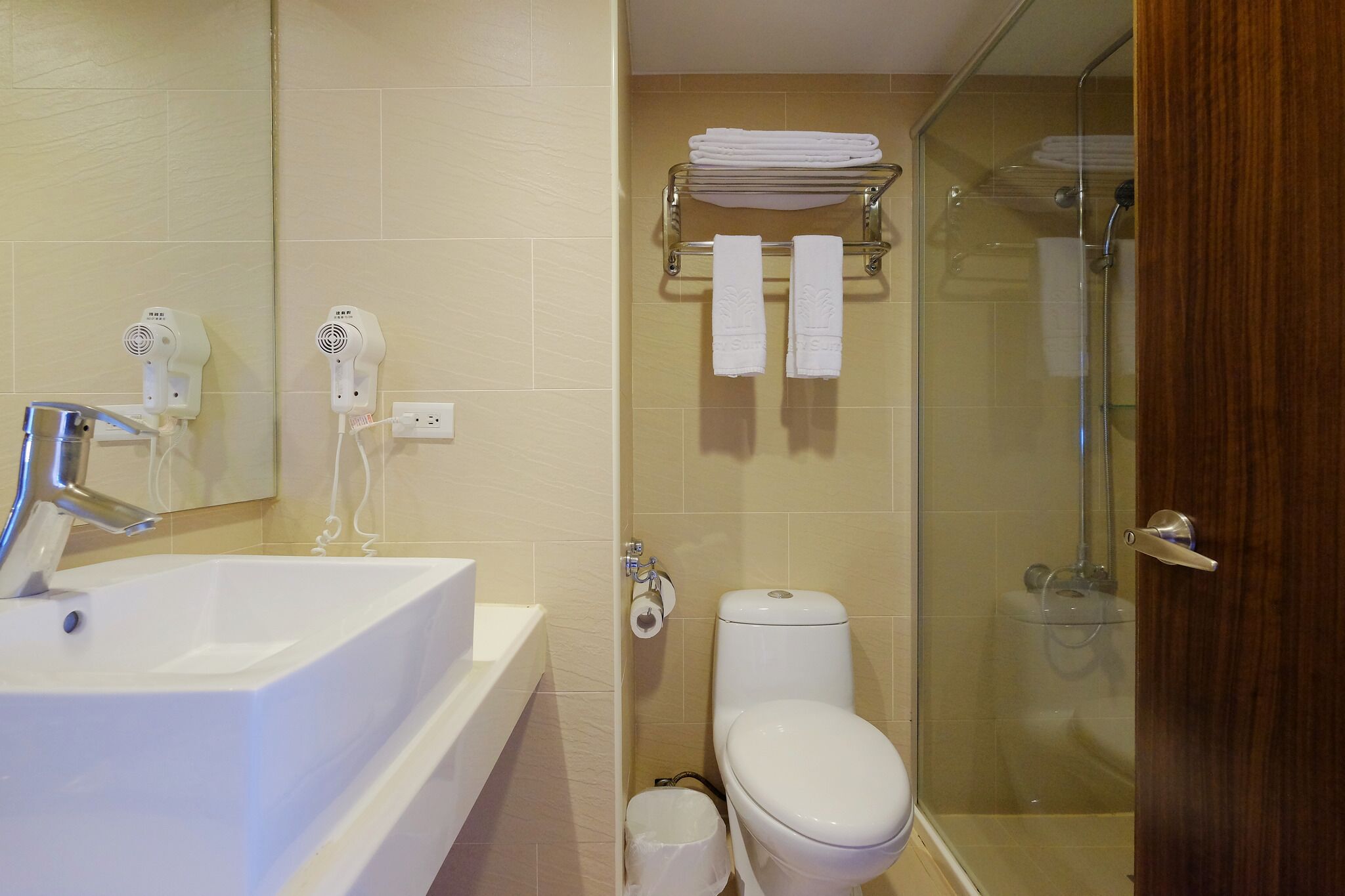 A bathroom with a sink, toilet, and glass shower enclosure.