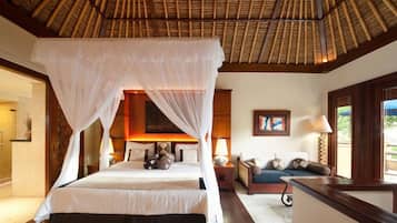 A bedroom with a canopy bed, a sofa, and a desk.