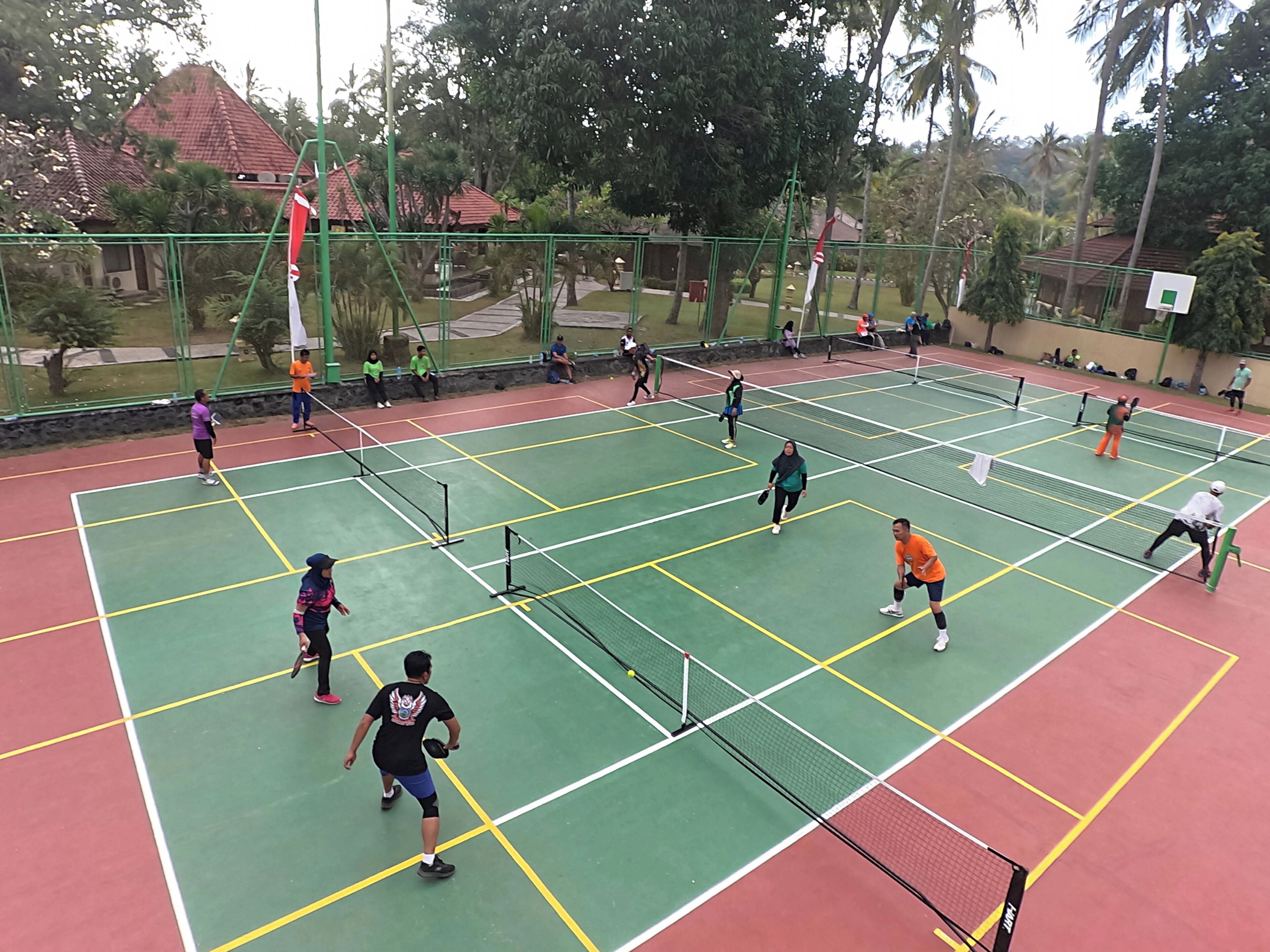 Een tennisbaan waar meerdere spelers een wedstrijd spelen.