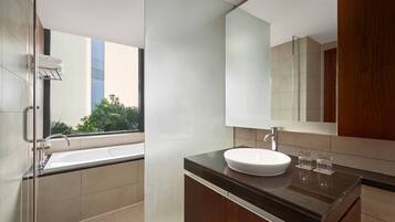 A modern bathroom with a large bathtub, a sink, and a mirror.