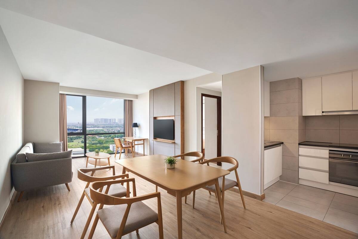 A modern apartment with a dining area, kitchen, and living space.