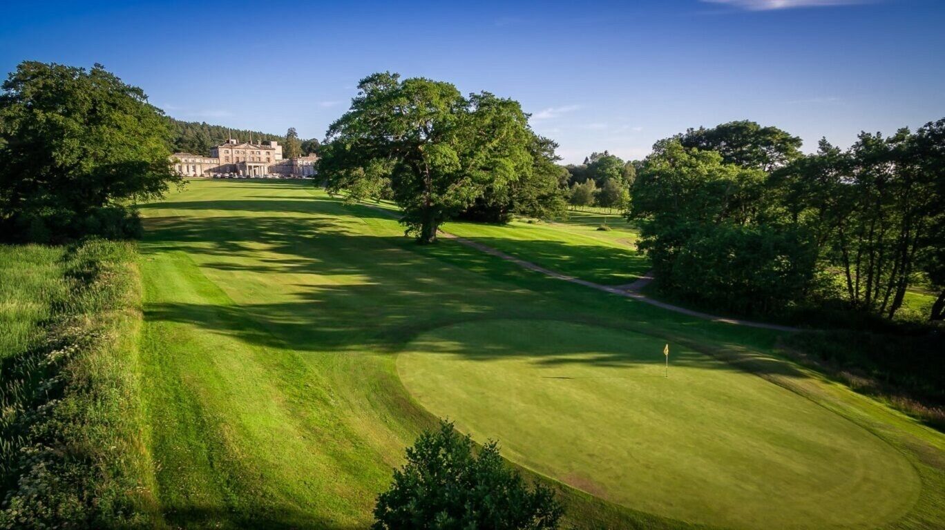 A golf course with a clubhouse in the background.