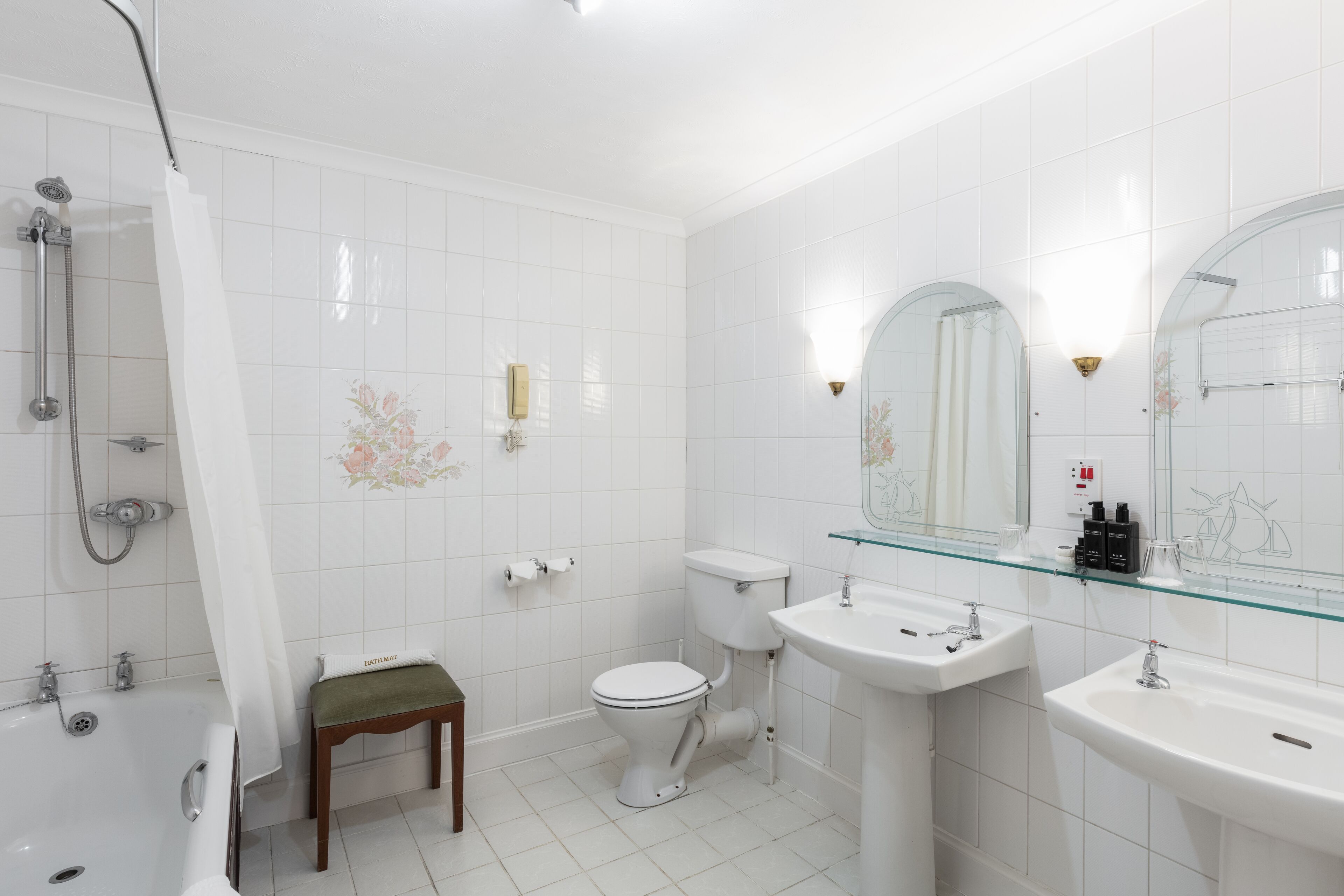 Ein modernes Badezimmer mit Badewanne, Toilette und zwei Waschbecken.