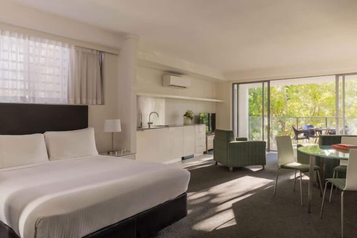 Une chambre d’hôtel dotée d’un grand lit, d’un coin repas et d’une kitchenette.