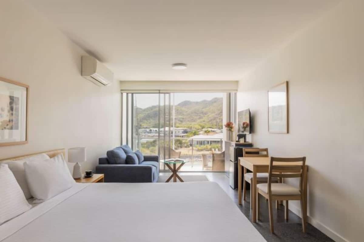 Une chambre d’hôtel avec un lit, un canapé, une table à manger et un téléviseur.