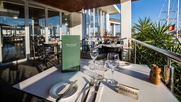 A table set with cutlery and a beverage menu, with a 'Reserved' sign on the table.