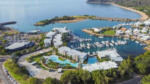 Marina costera con barcos, piscina y edificios residenciales.