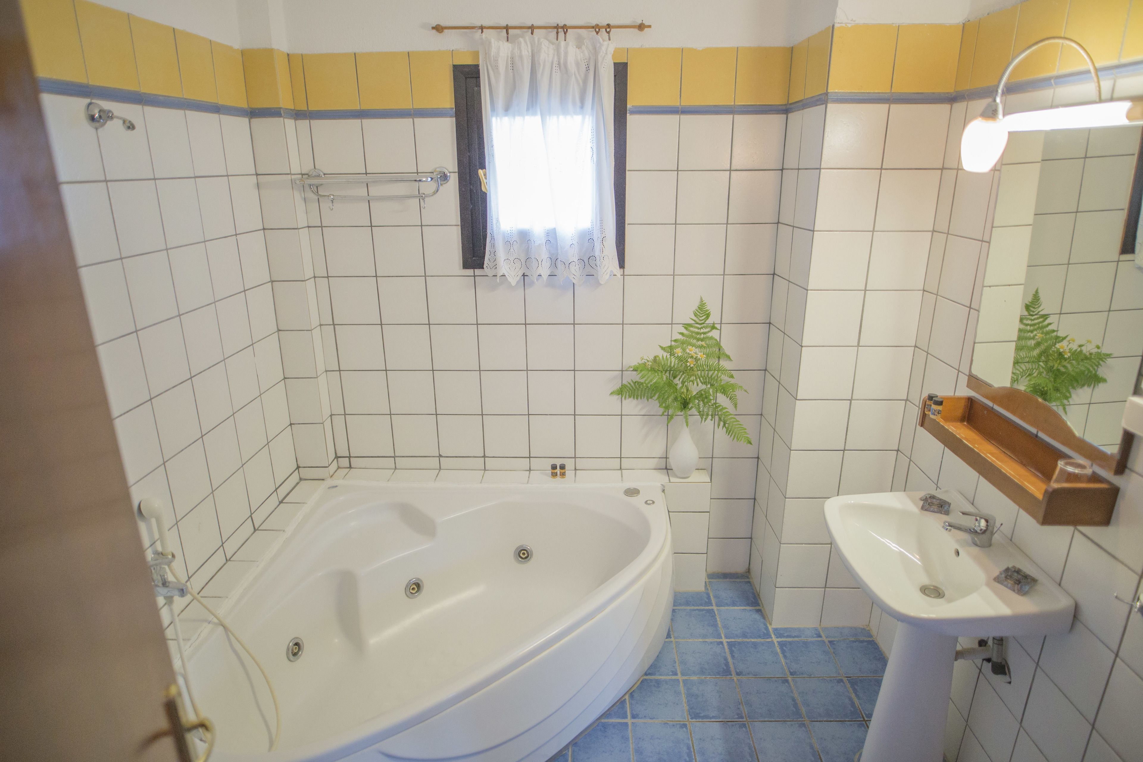 A bathroom with a bathtub, a sink, and a mirror.