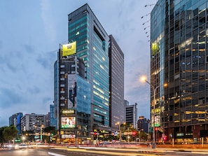A modern urban hotel with a prominent Checkinn sign, a rooftop terrace, and a view of the cityscape. - CHECK inn Taipei Xinyi (Taipei)
