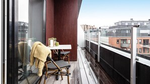 A balcony with a table, chairs, and a view of the cityscape. - Biz Apartment Gärdet (Stockholm)