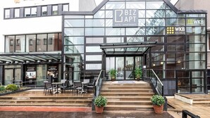 A modern hotel with a glass facade, labeled 'BIZ APT HOTEL APARTMENTS'. - Biz Apartment Gärdet (Stockholm)
