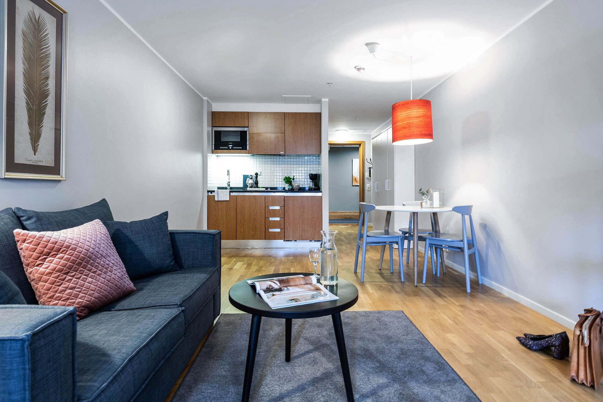 A modern living room with a sofa, a coffee table, and a dining area with chairs and a table.