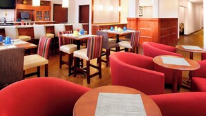 A hotel lobby with a bar area, seating arrangements, and a television. - Four Points by Sheraton Houston Hobby Airport (Houston)