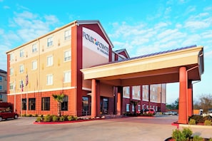 A hotel with a covered entrance, multiple windows, and a clear sky. - Four Points by Sheraton Houston Hobby Airport (Houston)