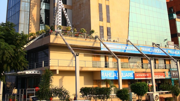 A modern building with a prominent 'Ginger' sign, a metal staircase, and a 'RAHEJA SQUARE' sign. - Ginger Manesar (Gurugram)