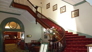 A grand staircase with red carpeted steps, a reception desk, and a sign indicating a balcony bar and restaurant. - Palace Hotel Kalgoorlie (Kalgoorlie)