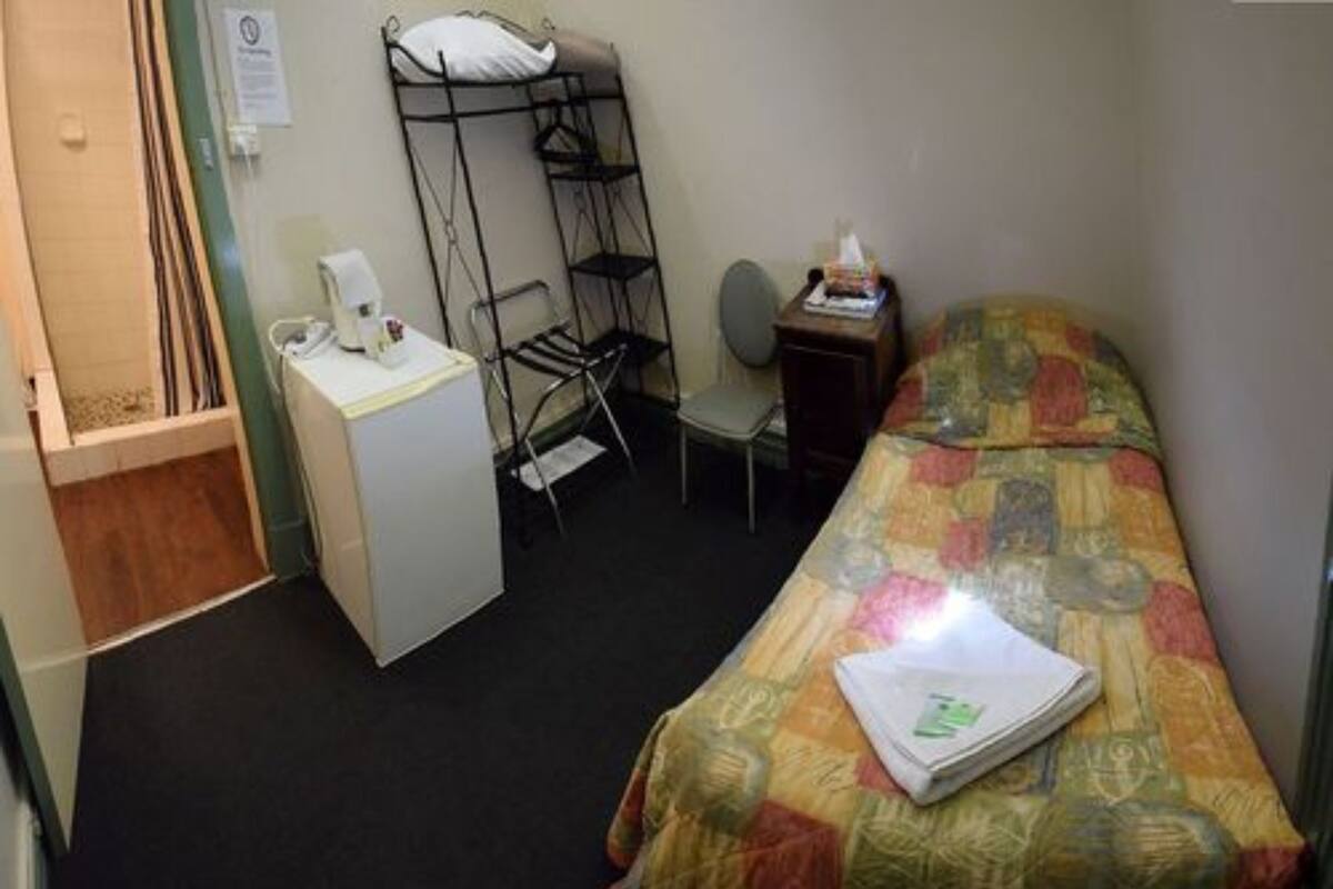 Une petite pièce, de taille modeste, comprenant un lit, un bureau et une chaise.