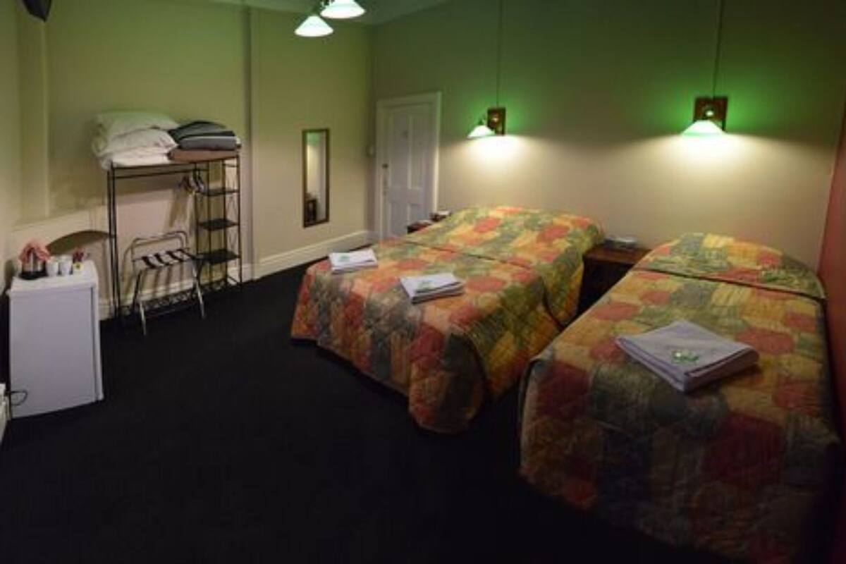 Une chambre avec deux lits, un bureau et une chaise.
