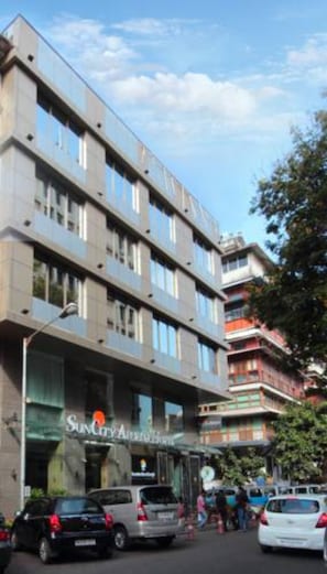 A multi-story hotel with a modern architectural design, featuring a prominent 'SunCity' sign on the ground floor.
