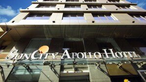 The exterior of the SunCity Apollo Hotel with a modern architectural design, featuring a prominent glass facade and a clear sky in the background. - Hotel Suncity Apollo (Mumbai)
