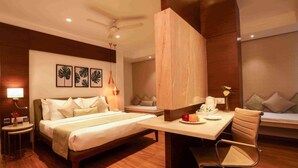 A modern hotel room with a bed, desk, chair, and artwork on the wall. - Hotel Suncity Apollo (Mumbai)