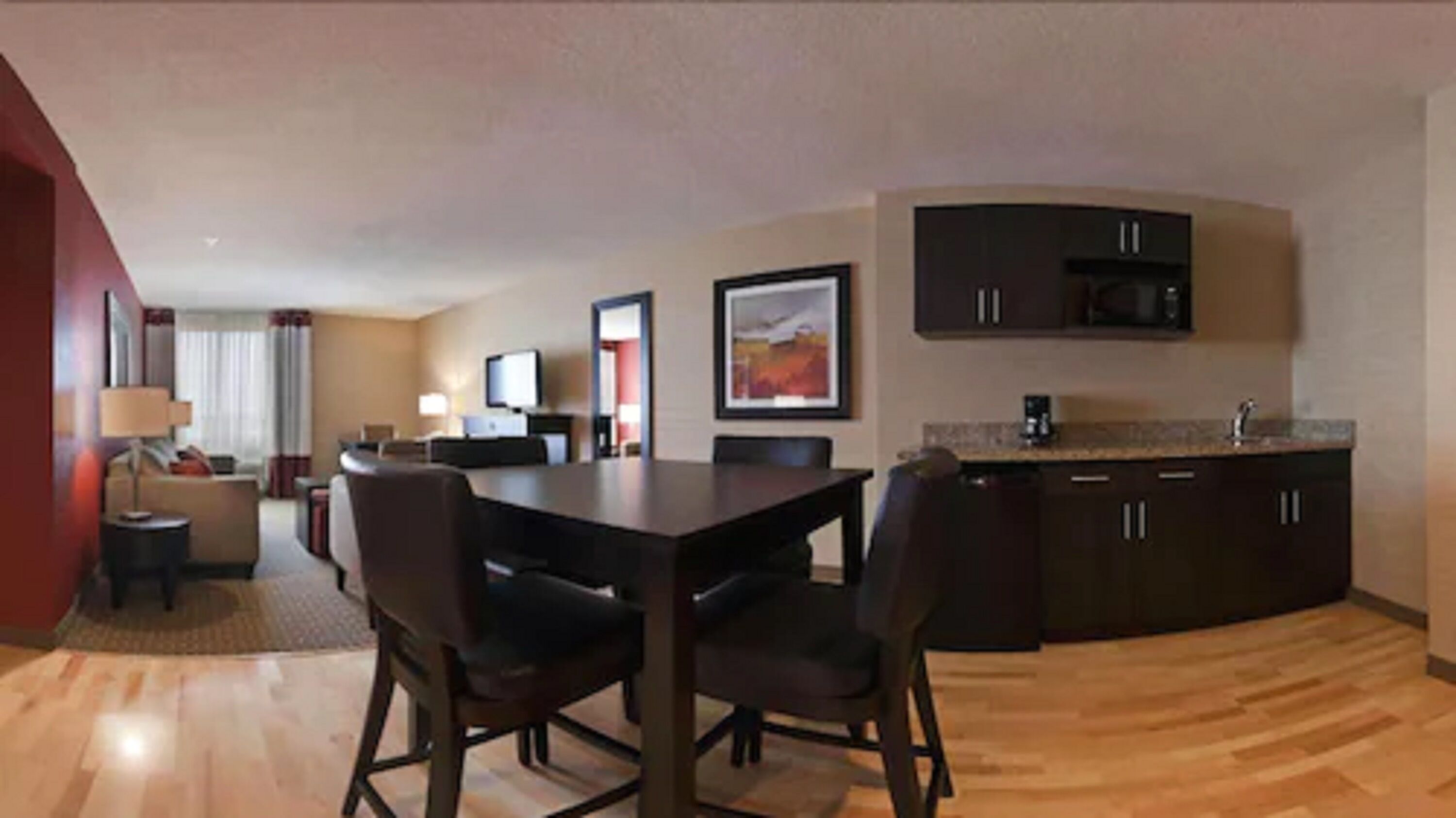 Una habitación de hotel moderna con comedor, cocina y sala de estar.
