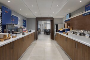 Un moderno comedor con estación de autoservicio, zona de asientos y vista al salón de comidas.