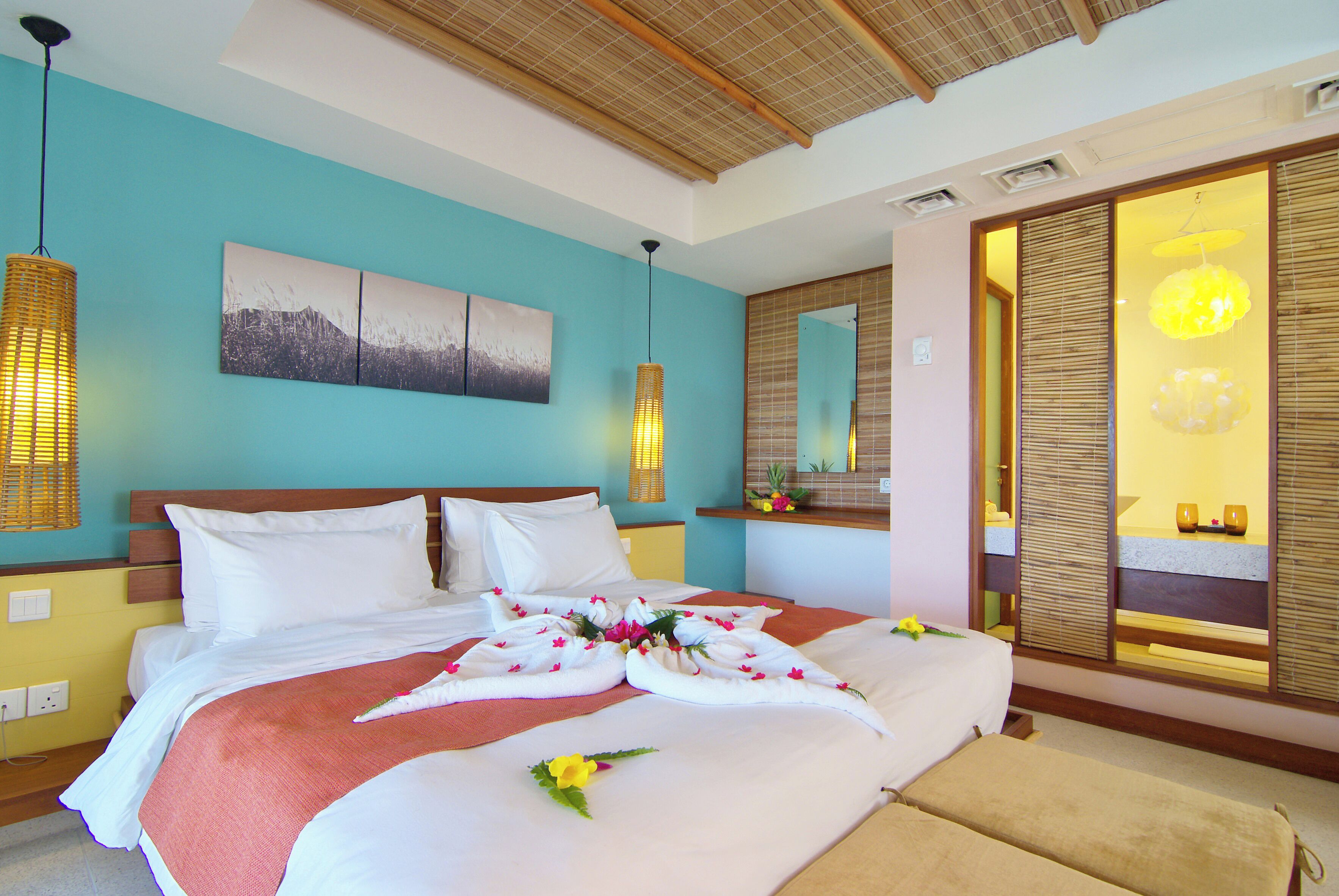 A hotel room with a bed, a large mirror, and a wooden ceiling.