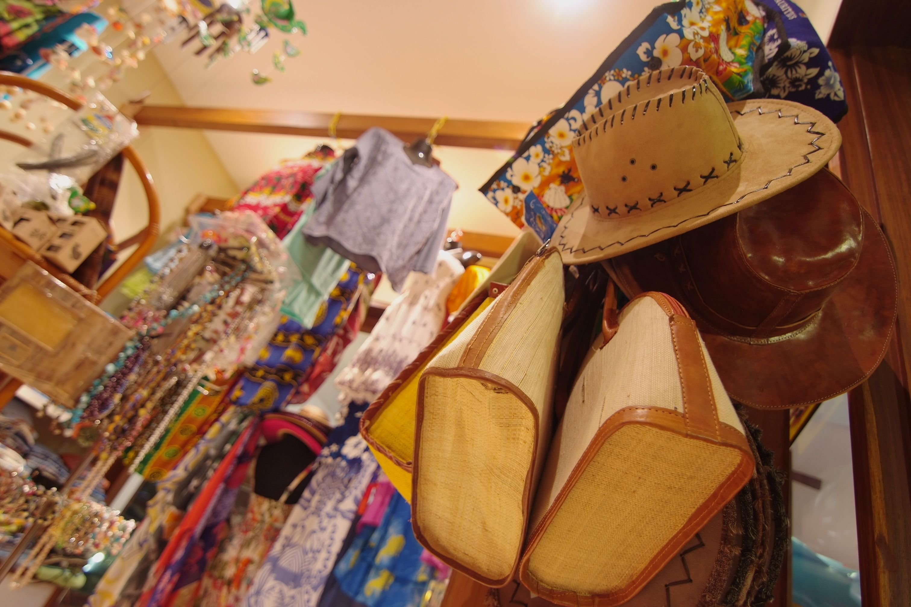 Una exhibición de sombreros y bolsos en una tienda.