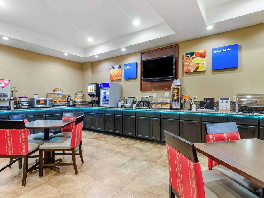 Una barra de desayuno con asientos y una pantalla de televisión.